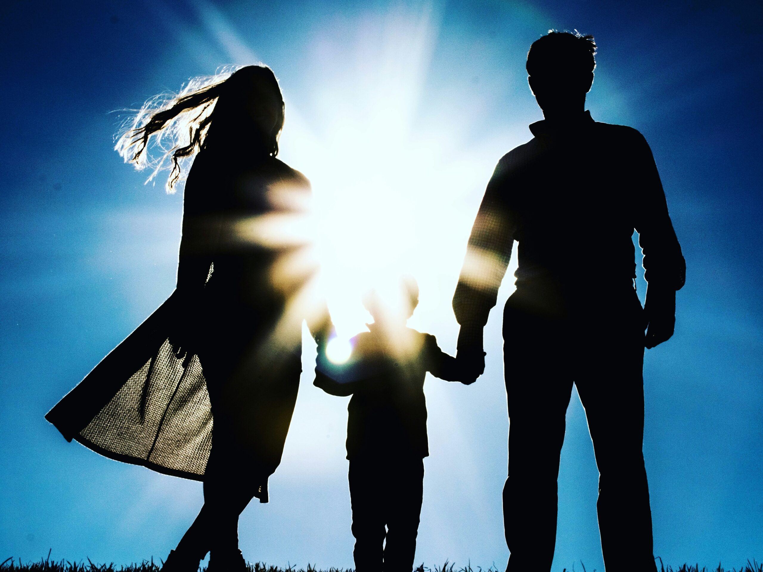 A parent holding their child under the sun. Adoptions in New Jersey.