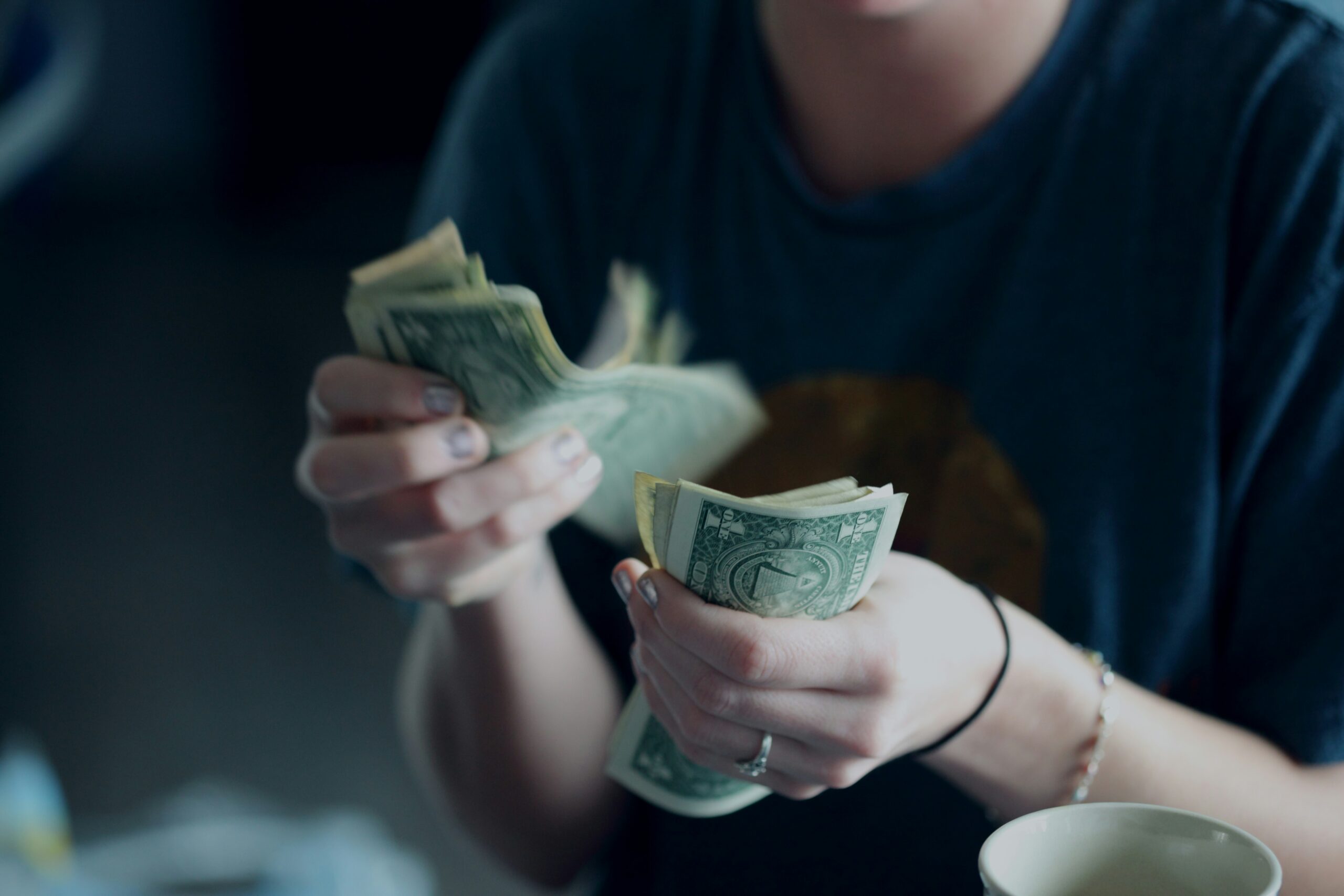 A woman counting her money while estimating the date when do alimony payments end in New Jersey.