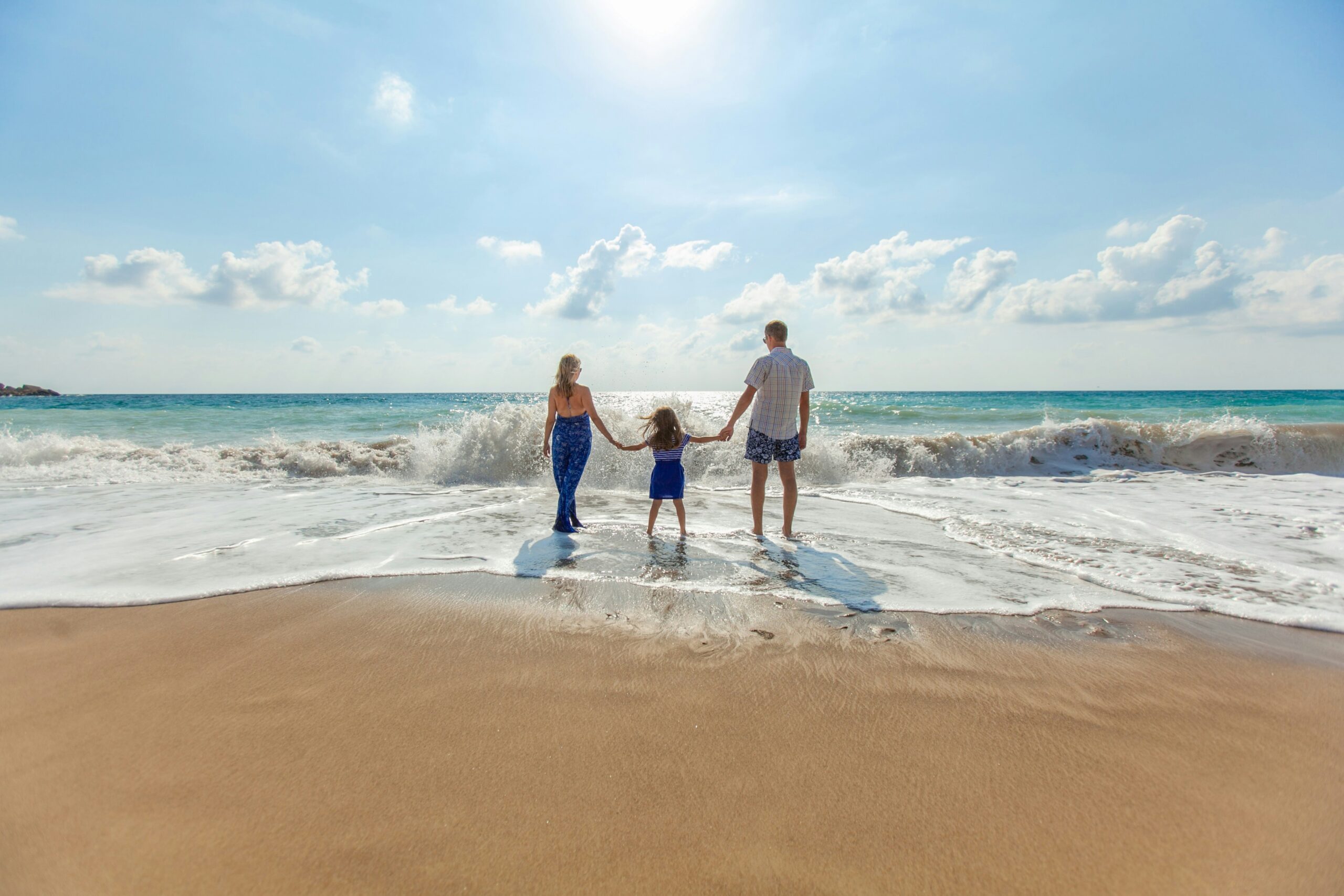 Family on foot feeling the sand in the beach. International adoption in New Jersey.