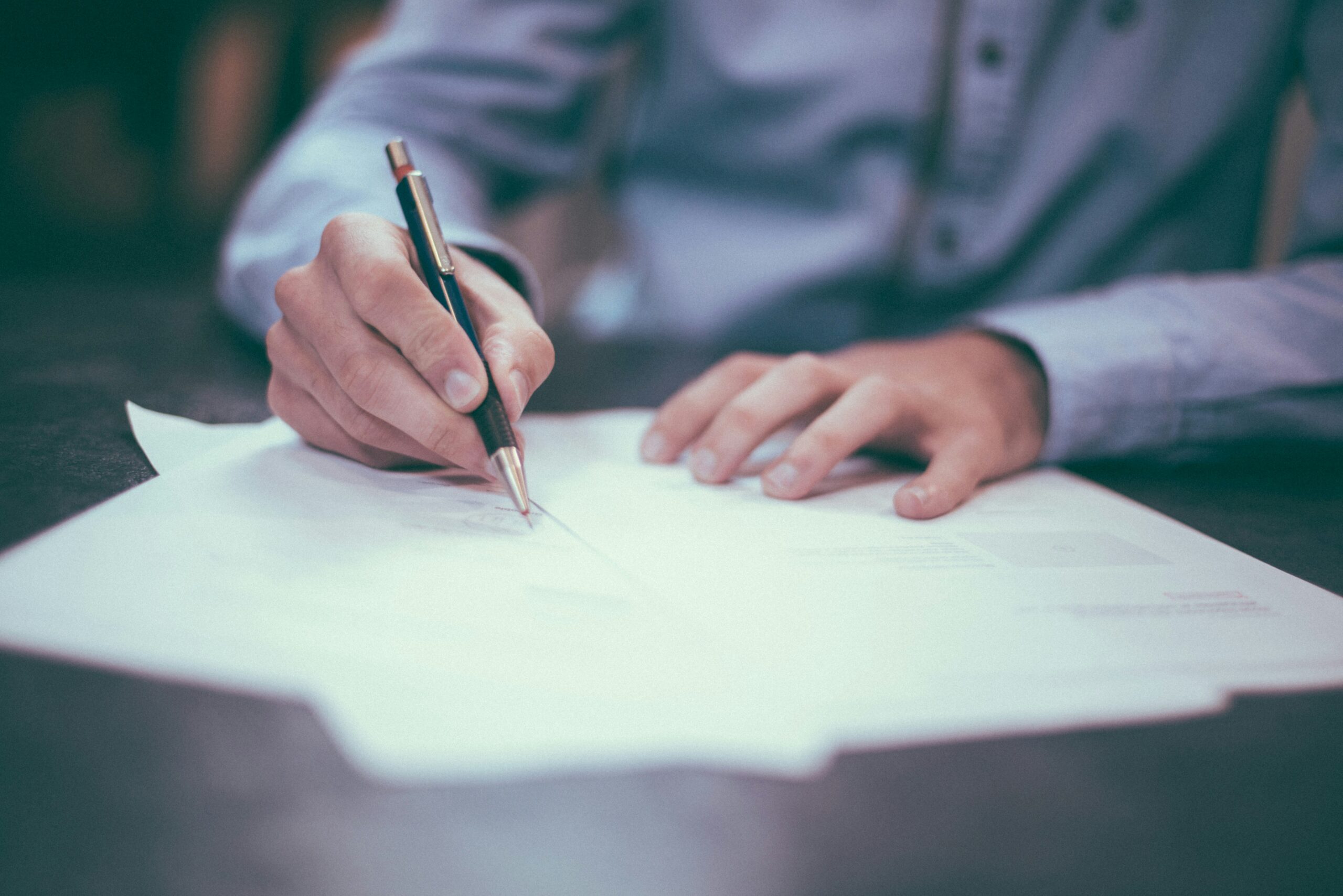 A lawyer for adoption in Ocean County signing a document.