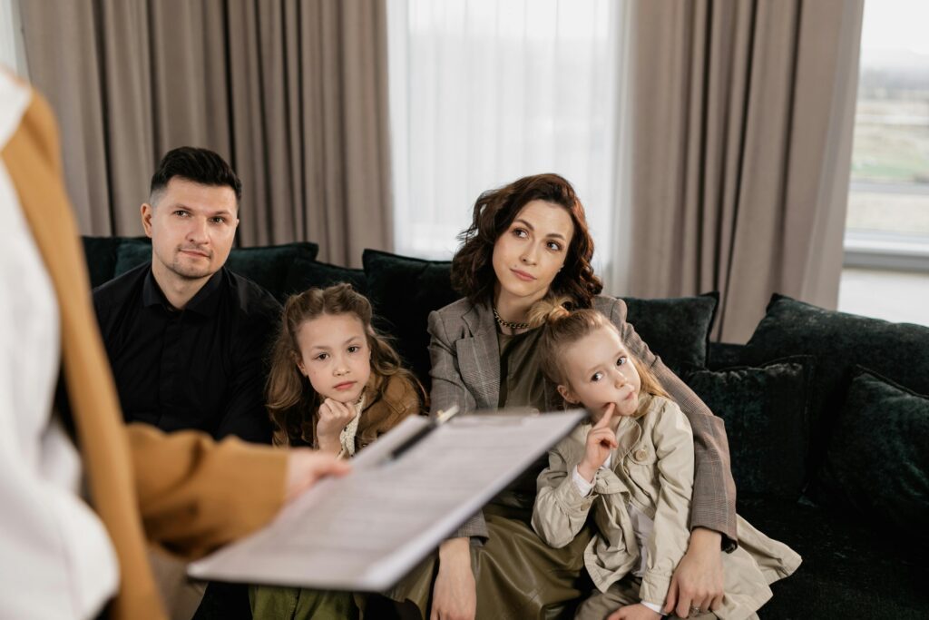 A family sitting together on a couch during a meeting, representing the collaborative process of custody evaluation in Ocean County, New Jersey